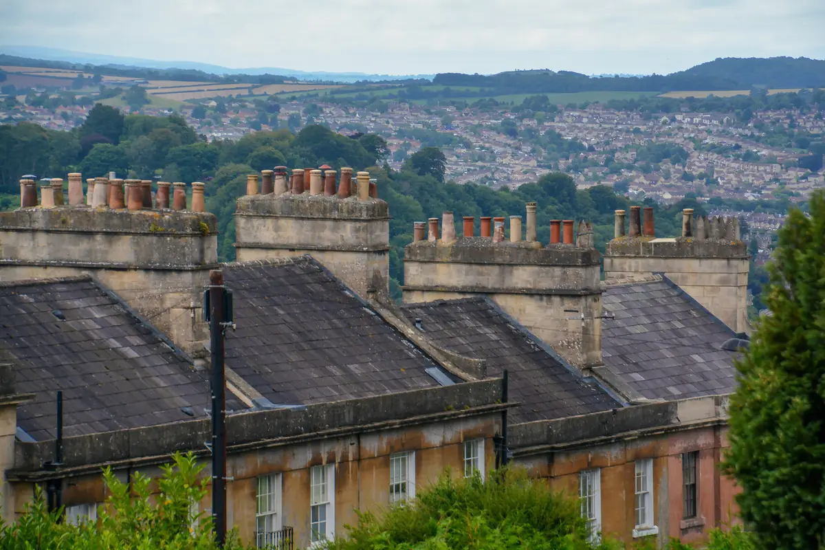 Terrace rooftops and chimneys in Bath with the city and hills beyond