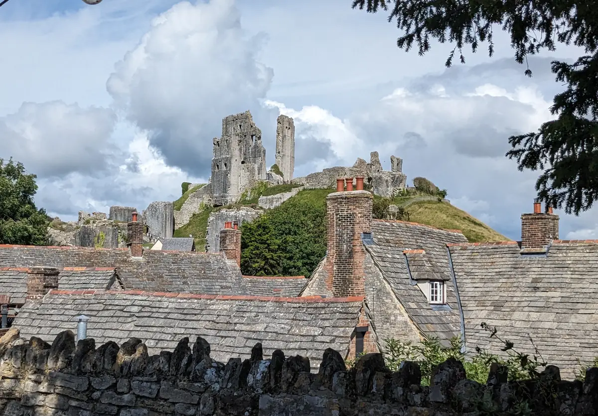 Stone roofs of Corfe village with the castle ruins behind